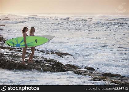 Surfers carrying surfboards on beach