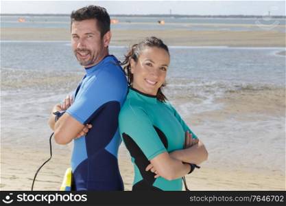 surfers couple looking at camera