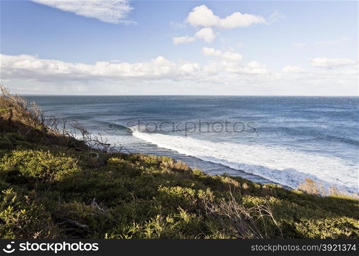 Surfers riding the waves at Bells Beach, Great Ocean Road, Australia, on a cold winter day