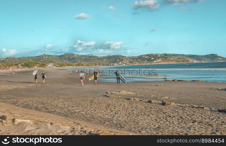 Surfers walking on the beach, image of surfers with their surfboard walking on the beaches of Nicaragua