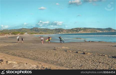 Surfers walking on the beach, image of surfers with their surfboard walking on the beaches of Nicaragua