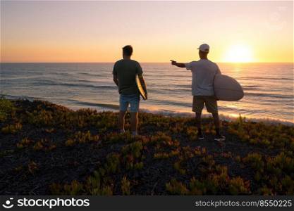 Surfers watching the waves at sunset on top of a sand dune in Maceda, Ovar -  Portugal.