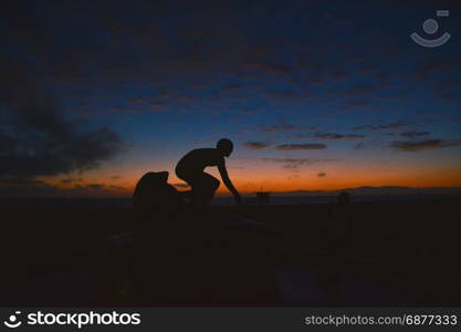 Surfing at Sunset. Young Man Riding Wave at Sunset. Outdoor Active Lifestyle.