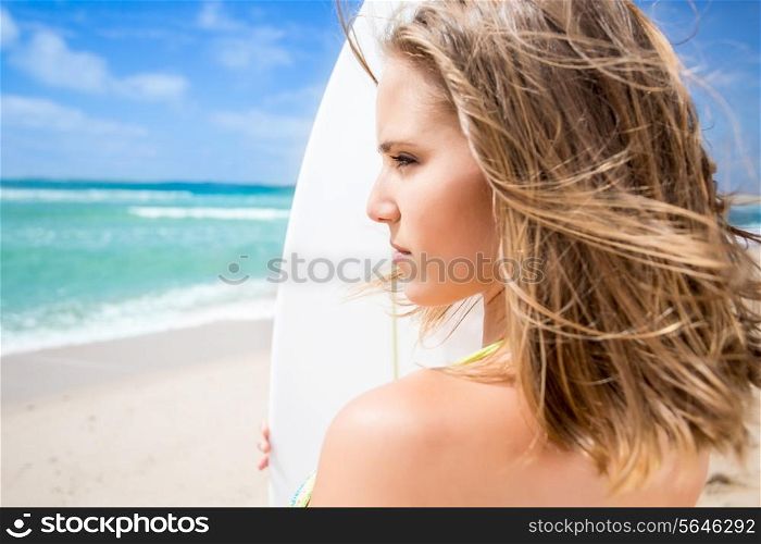 Surfing beautiful woman waiting for the waves on the beach