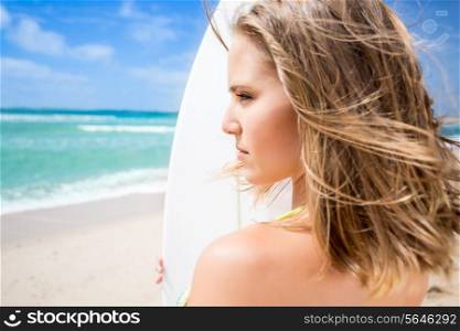 Surfing beautiful woman waiting for the waves on the beach