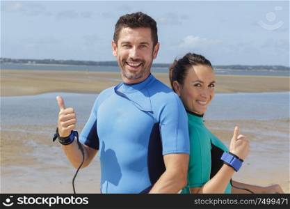 surfing couple making thumbs up gesture