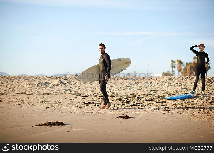 Surfing couple with surfboards on Venice Beach, California, USA