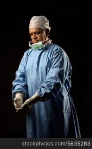 Surgeon looking at his gloves