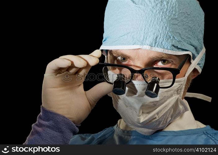 Surgeon looks over magnifying glasses