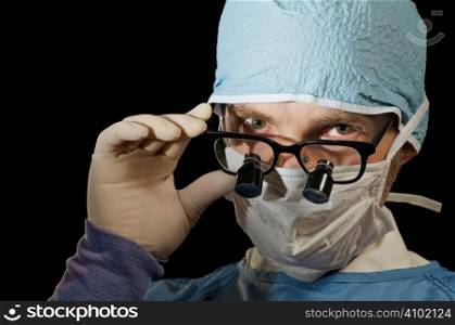 Surgeon looks over magnifying glasses