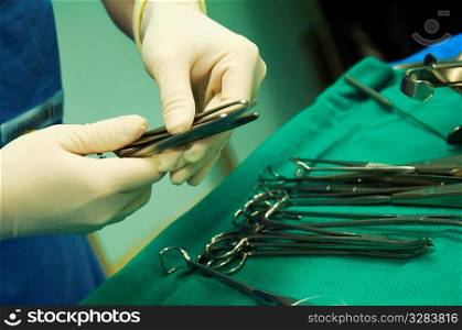 Surgeon selecting sterilized tool for operation.