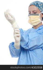 Surgeon wearing surgical mask putting on latex gloves