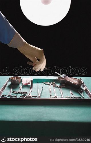 Surgeons hand reaching for medical equipment in operating theatre