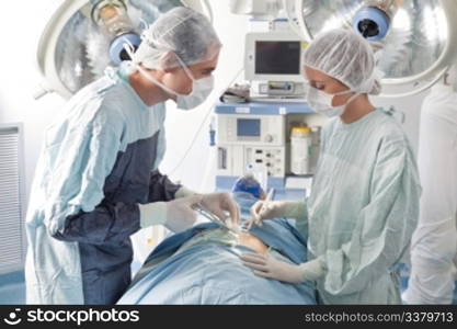 Surgeons performing operation on patient in hospital