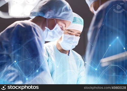 surgery, healthcare, medicine and people concept - group of surgeons at operation in operating room at hospital with virtual diagram projection. group of surgeons in operating room at hospital