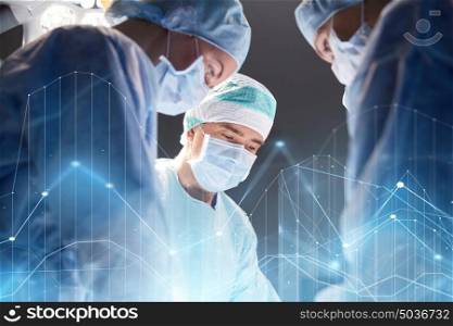 surgery, healthcare, medicine and people concept - group of surgeons at operation in operating room at hospital with virtual diagram projection. group of surgeons in operating room at hospital