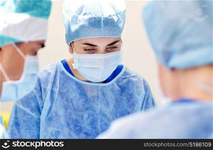 surgery, medicine and people concept - group of surgeons at operation in operating room at hospital. group of surgeons in operating room at hospital