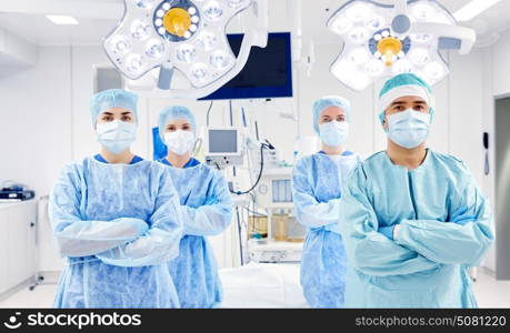 surgery, medicine and people concept - group of surgeons in operating room at hospital. group of surgeons in operating room at hospital