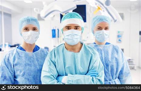 surgery, medicine and people concept - group of surgeons in operating room at hospital. group of surgeons in operating room at hospital. group of surgeons in operating room at hospital