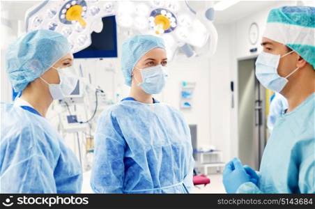surgery, medicine and people concept - group of surgeons in operating room at hospital. group of surgeons in operating room at hospital