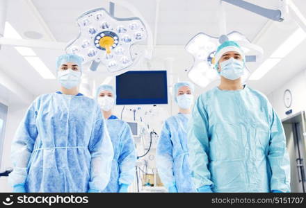 surgery, medicine and people concept - group of surgeons in operating room at hospital. group of surgeons in operating room at hospital