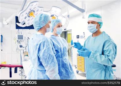 surgery, medicine and people concept - group of surgeons in operating room at hospital. group of surgeons in operating room at hospital