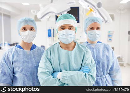 surgery, medicine and people concept - group of surgeons in operating room at hospital