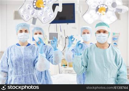surgery, medicine and people concept - group of surgeons in operating, room at hospital