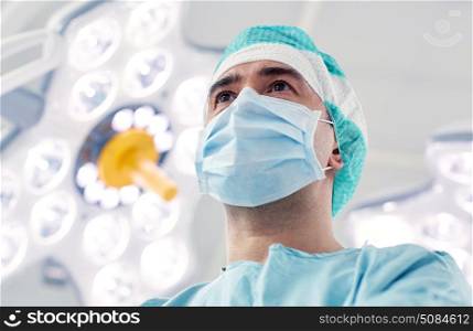surgery, medicine and people concept - surgeon in mask operating room at hospital. surgeon in operating room at hospital. surgeon in operating room at hospital