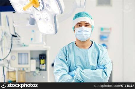 surgery, medicine and people concept - surgeon in mask operating room at hospital. surgeon in operating room at hospital