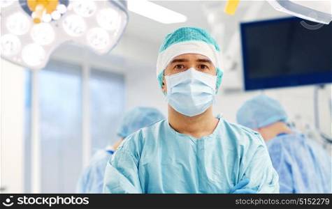 surgery, medicine and people concept - surgeon in mask operating room at hospital. surgeon in operating room at hospital