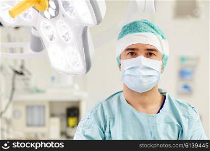 surgery, medicine and people concept - surgeon in mask operating room at hospital