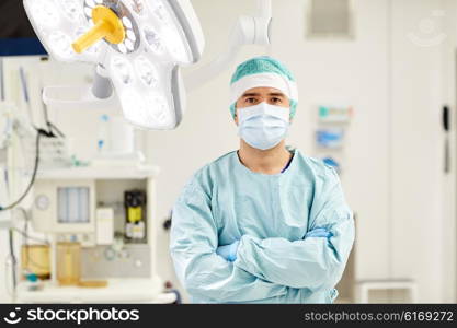 surgery, medicine and people concept - surgeon in mask operating room at hospital