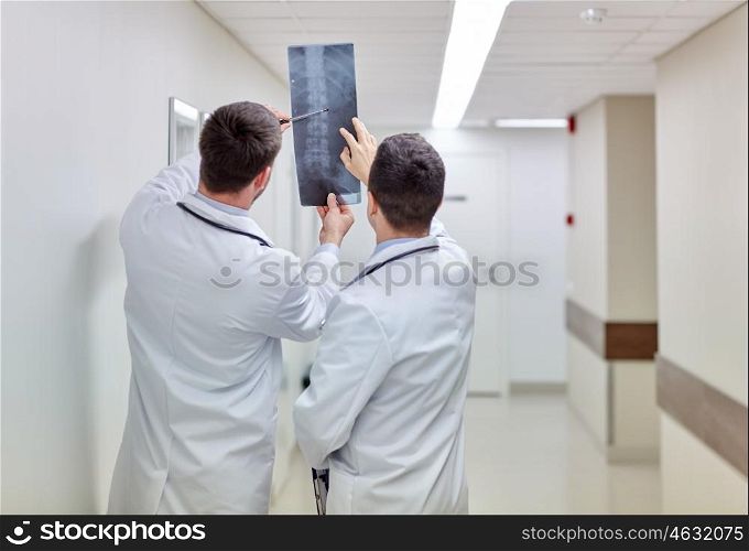 surgery, people, healthcare and medicine concept - medics with spine x-ray scan at hospital