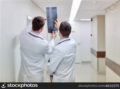 surgery, people, healthcare and medicine concept - medics with spine x-ray scan at hospital