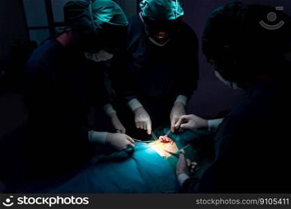 Surgical team performing surgery to patient in sterile operating room. In a surgery room lit by a lamp, a professional and confident surgical team provides medical care to an unconscious patient.. Surgical team performing surgery to patient in sterile operating room.
