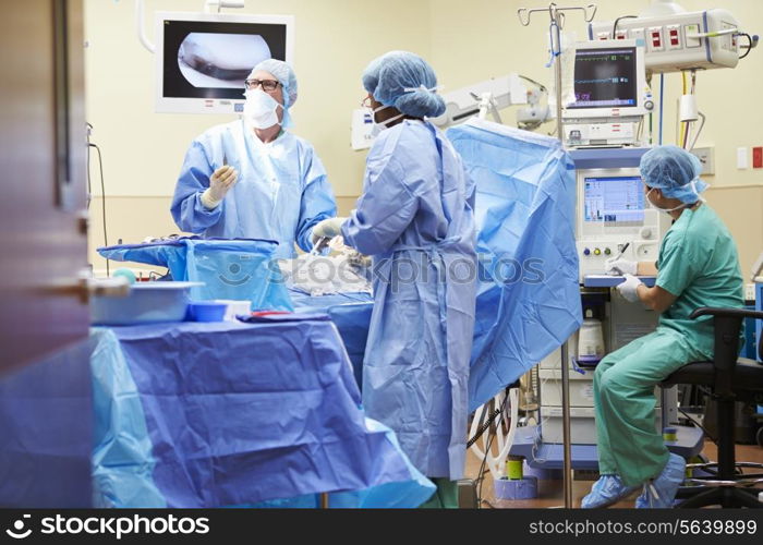 Surgical Team Working In Operating Theatre