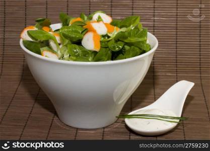 surimi and tzatziki. a photo of a cup of salad with surimi and a spoon of tzatziki cream