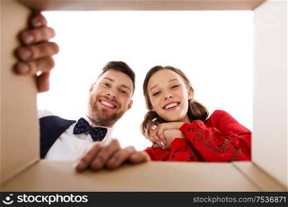 surprise, delivery and holidays concept - happy couple looking into open christmas gift box. happy couple looking into open christmas gift box