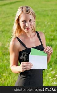 Surprise envelope young attractive businesswoman opening letter sunny meadow