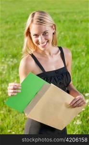 Surprise envelope young attractive businesswoman opening letter sunny meadow