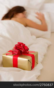 Surprise present - young woman sleeping in white bedroom