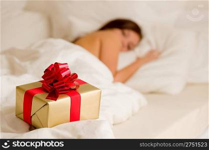 Surprise present - young woman sleeping in white bedroom