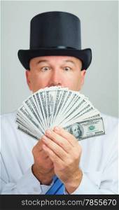 Surprised and amazed middle aged man in a retro top hat with money.Focus on the cash.