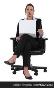 surprised businesswoman sitting in a chair and holding laptop