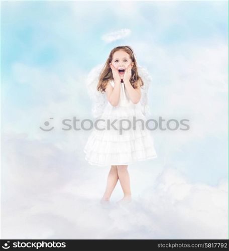 Surprised cheerful little girl among white clouds