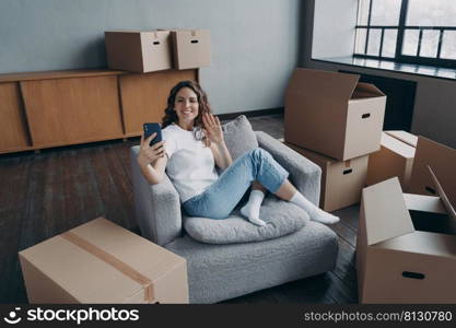 Surprised excited young woman is sitting in front of laptop having video call. Caucasian girl in orange shirt is remote worker at the kitchen at home. Distance work on quarantine concept.. Surprised excited young woman is sitting in front of laptop having video call. Distance work.