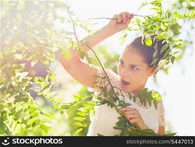 Surprised girl in foliage looking on copy space