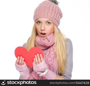 Surprised girl in winter clothes reading heart shaped postcard