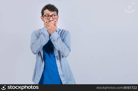 Surprised man covering his mouth looking to the side, Surprised man in glasses covering his mouth looking to the side, concept of man keeping a secret
